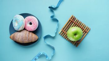 Contrast of healthy and indulgent foods with a measuring tape for weight management.
